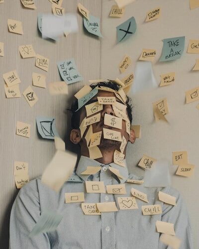 Leader in work clothes looking stressed covered in post-it notes